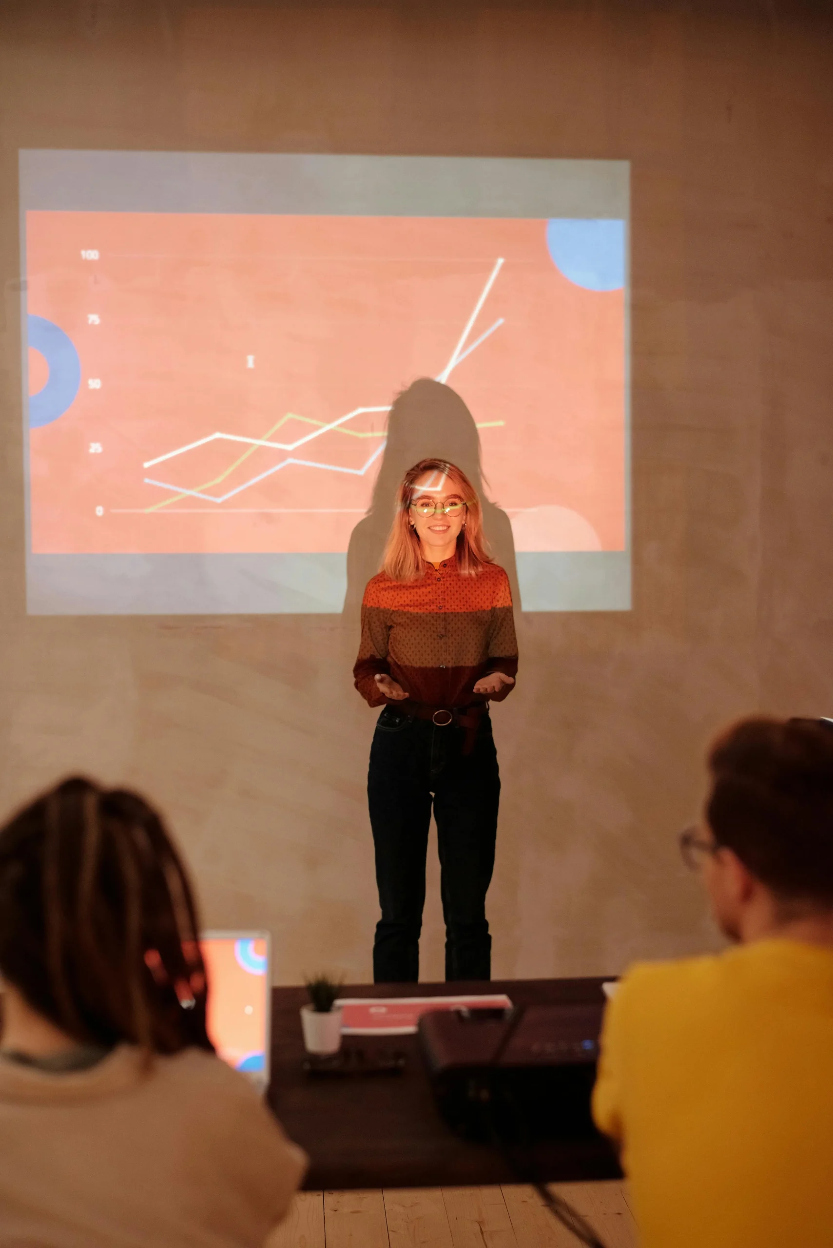 A student presenting in front of a projected chart